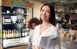 Woman owning franchise. Dark-haired woman owning restaurant standing and holding documents