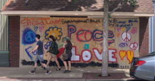 Boarded up store front with peace and love signs