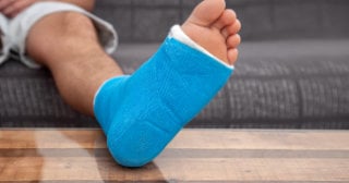 Foot in a blue cast, resting on a coffee table