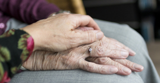 close up view of elderly couple holding hands