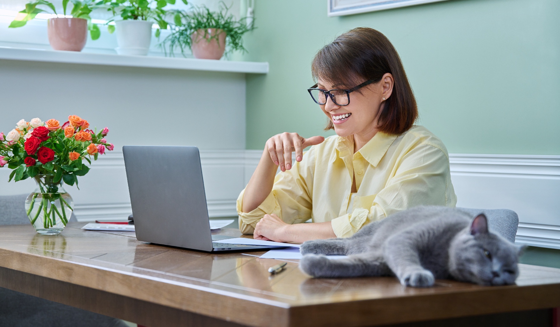 Business woman working from home, using laptop, along with pet cat