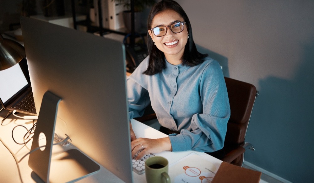 smiling woman working late at her computer