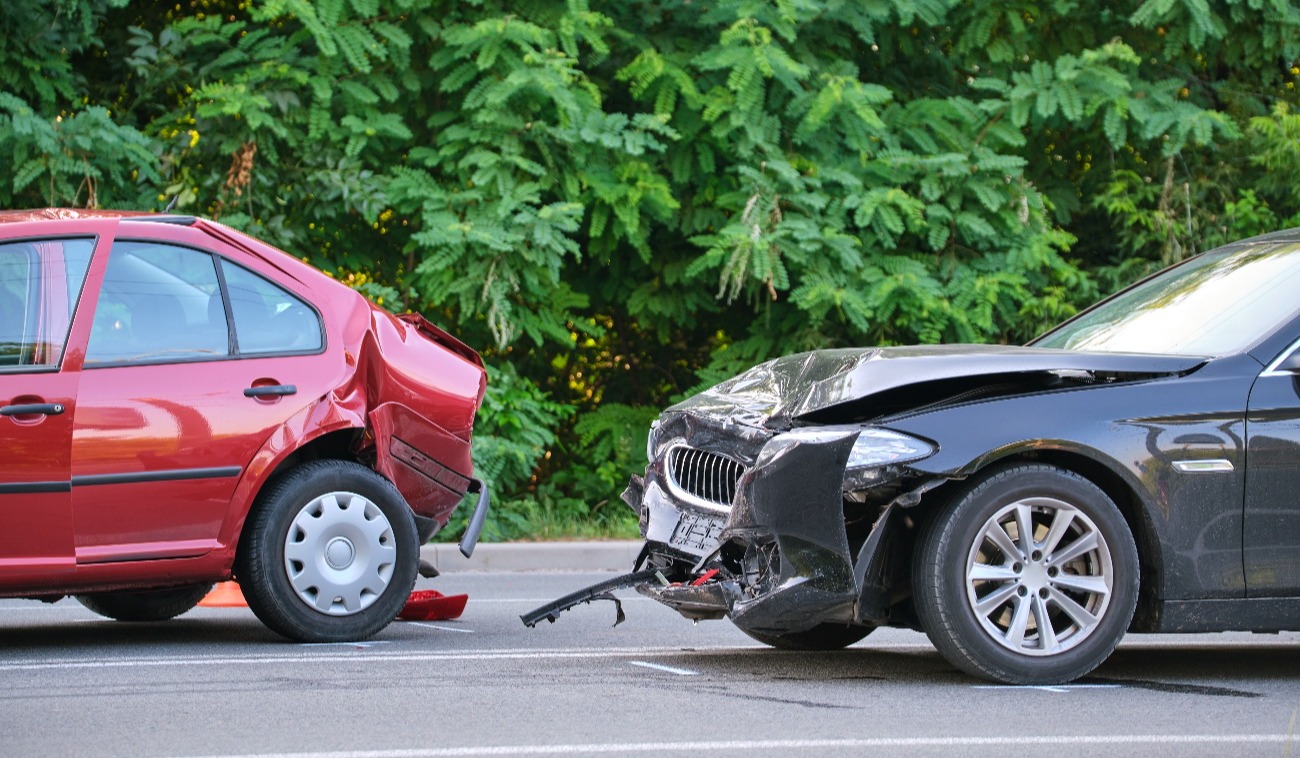 car accident involving a red car being rear-ended by a black car